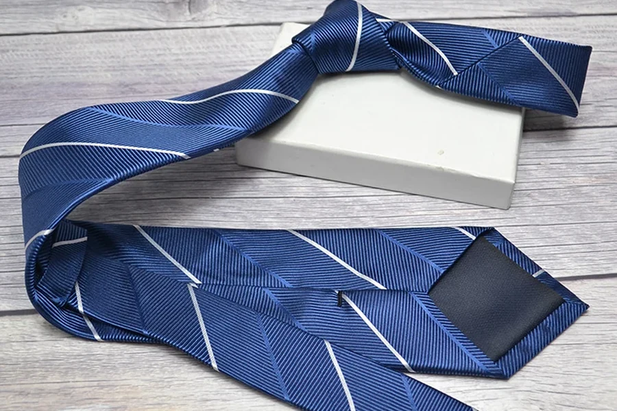 Blue striped tie draped around a plain light-colored presentation box