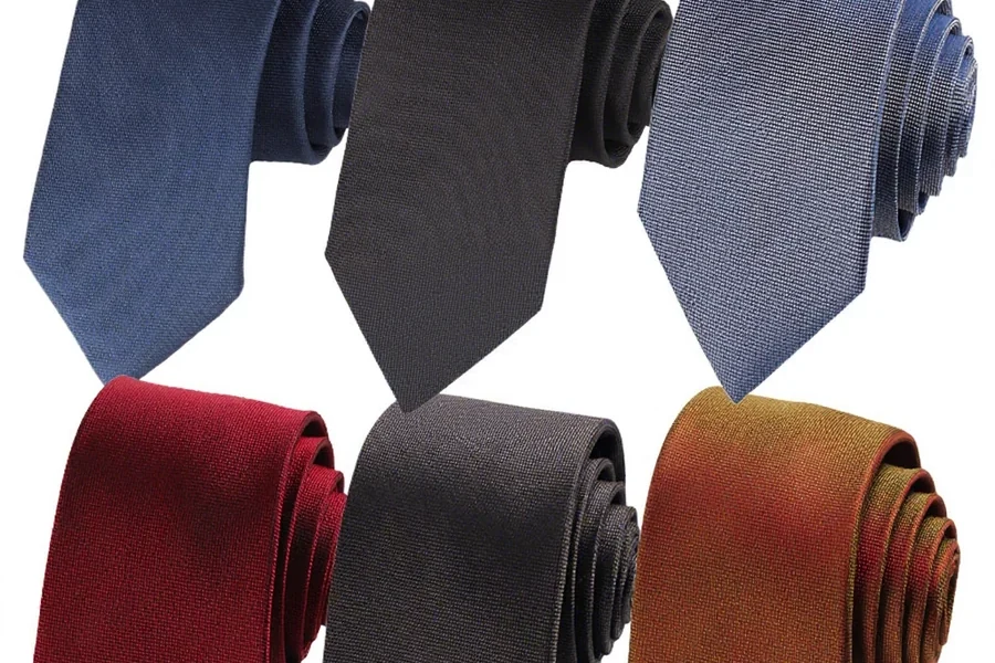 Six rolled ties in blue, black, burgundy, gray and gold tones