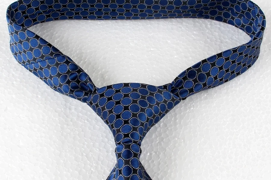 Blue tie with repeating oval motifs tied in a knot