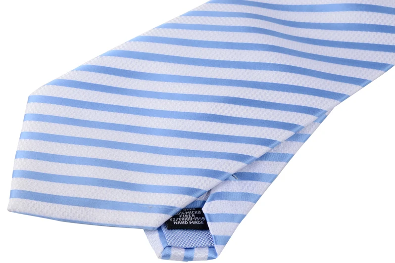 Reverse of a light blue striped tie showing the tip, seam and small label