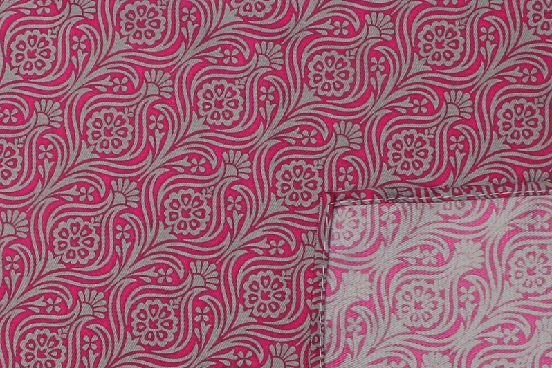 Pink and gray paisley fabric with a folded corner showing the reverse