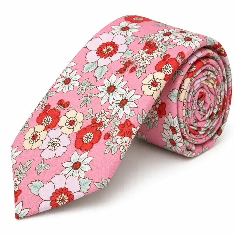 A rolled pink tie with red, cream and white flowers.
