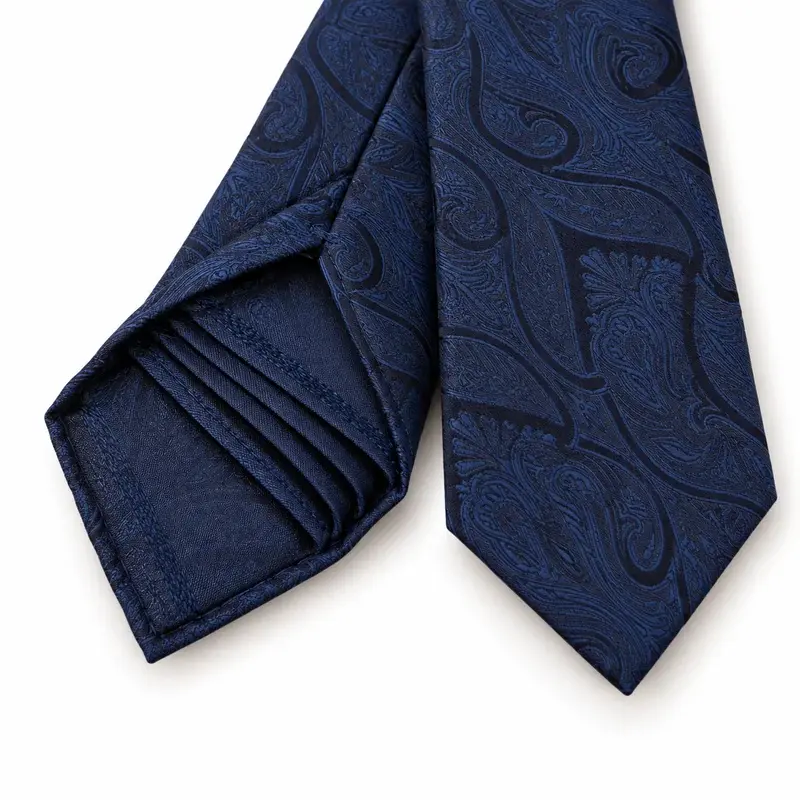 Navy paisley silk tie showing its finished front and layered seven-fold reverse.