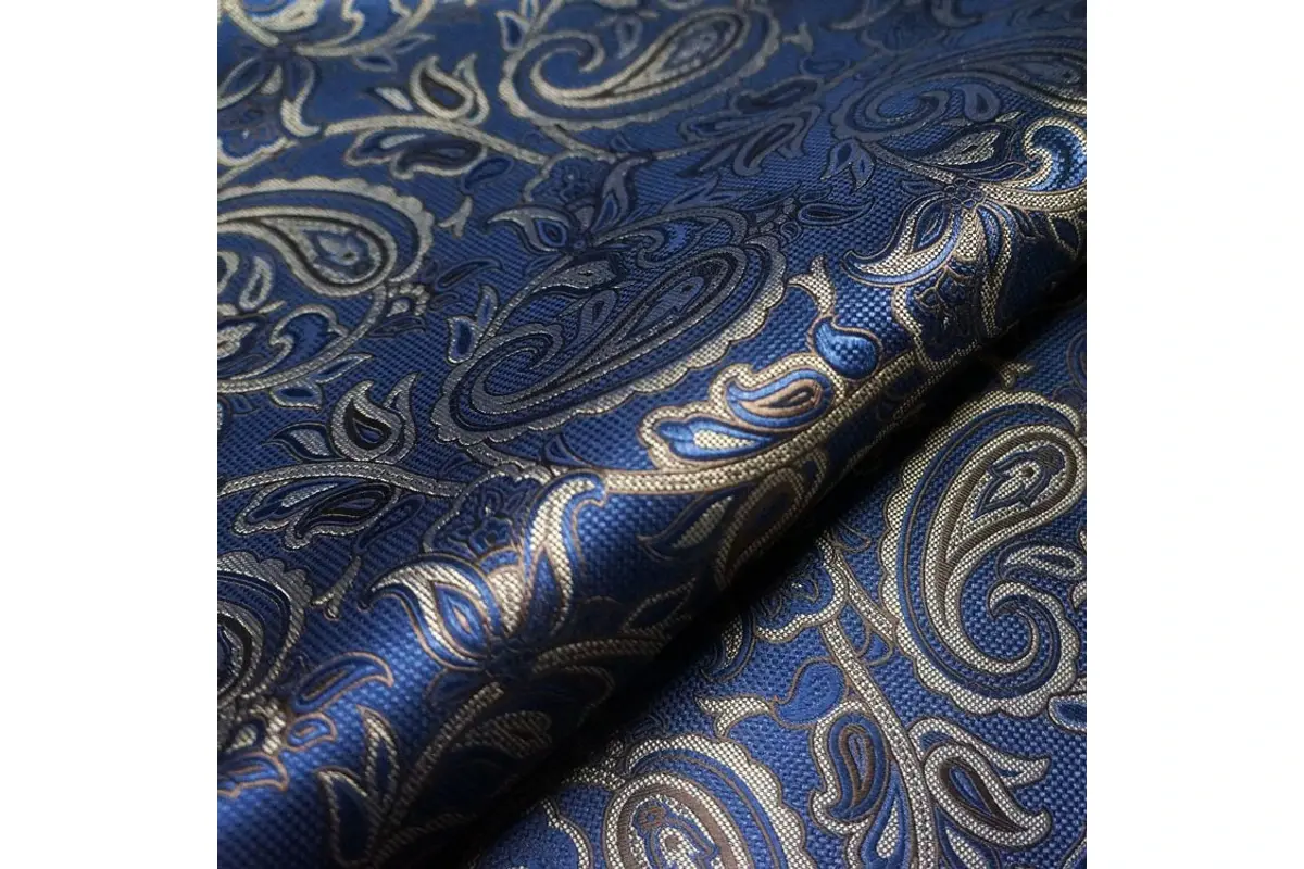 Close-up of blue and gold paisley fabric.