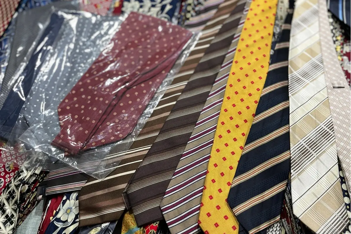 Assorted striped and patterned ties, some in clear sleeves.