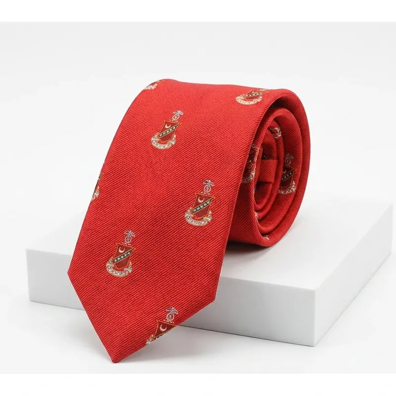 A rolled red tie with repeating crest motifs.