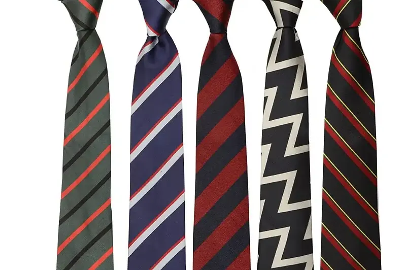 Five knotted neckties with stripes and a zigzag pattern.