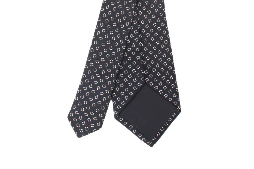 Wide and narrow ends of a dark patterned necktie.