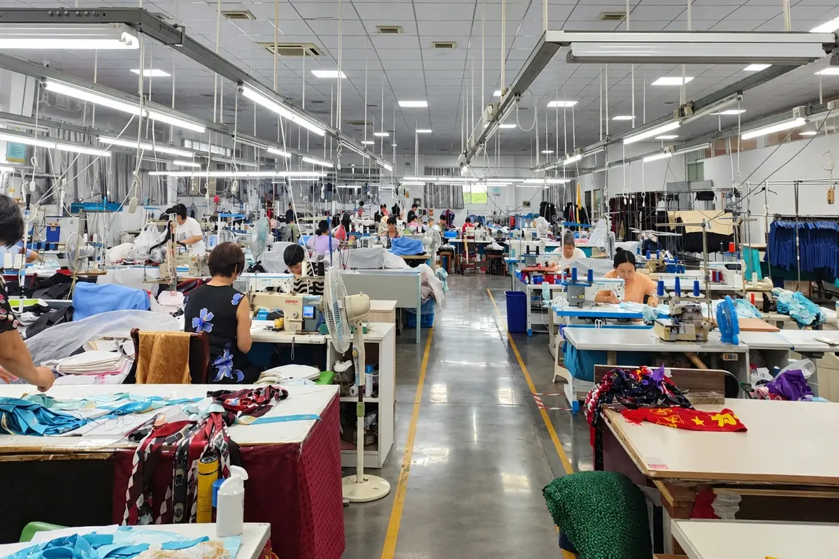 Workers at sewing stations in a garment workshop.