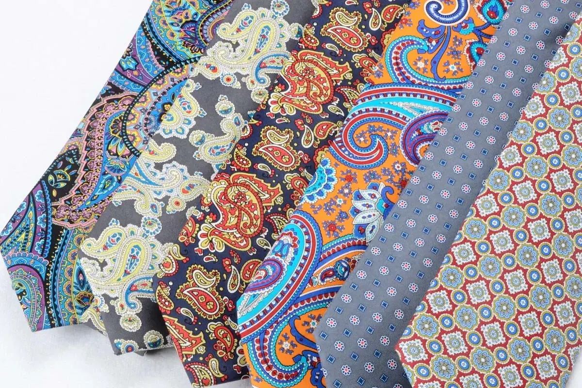 Assorted necktie fabrics with paisley and geometric patterns.