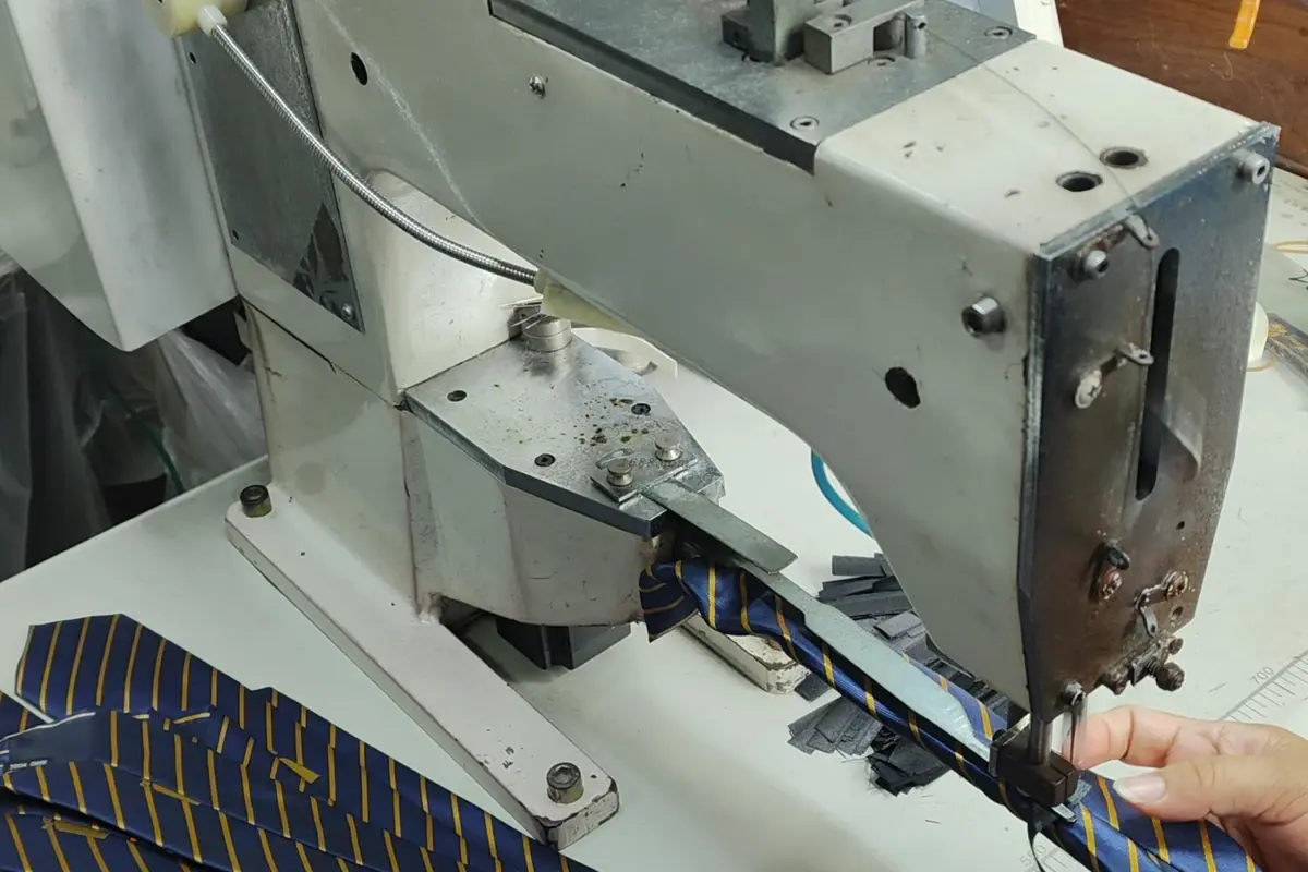 Striped tie fabric being sewn on an industrial sewing machine