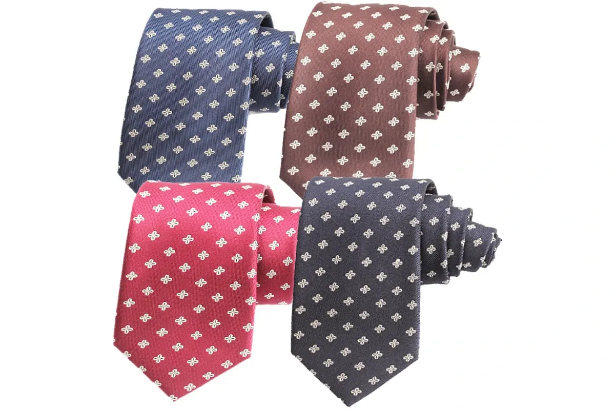 Four ties in blue, brown, red and dark gray with small pale repeating motif.