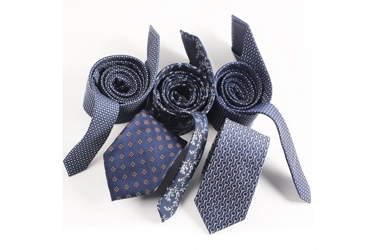 Six navy and blue ties with small geometric and repeating patterns.