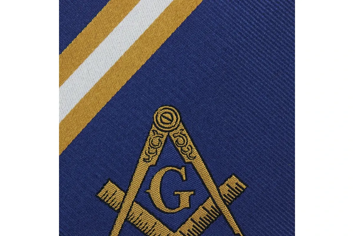 Close-up of a gold emblem below gold and white stripes on navy tie fabric.