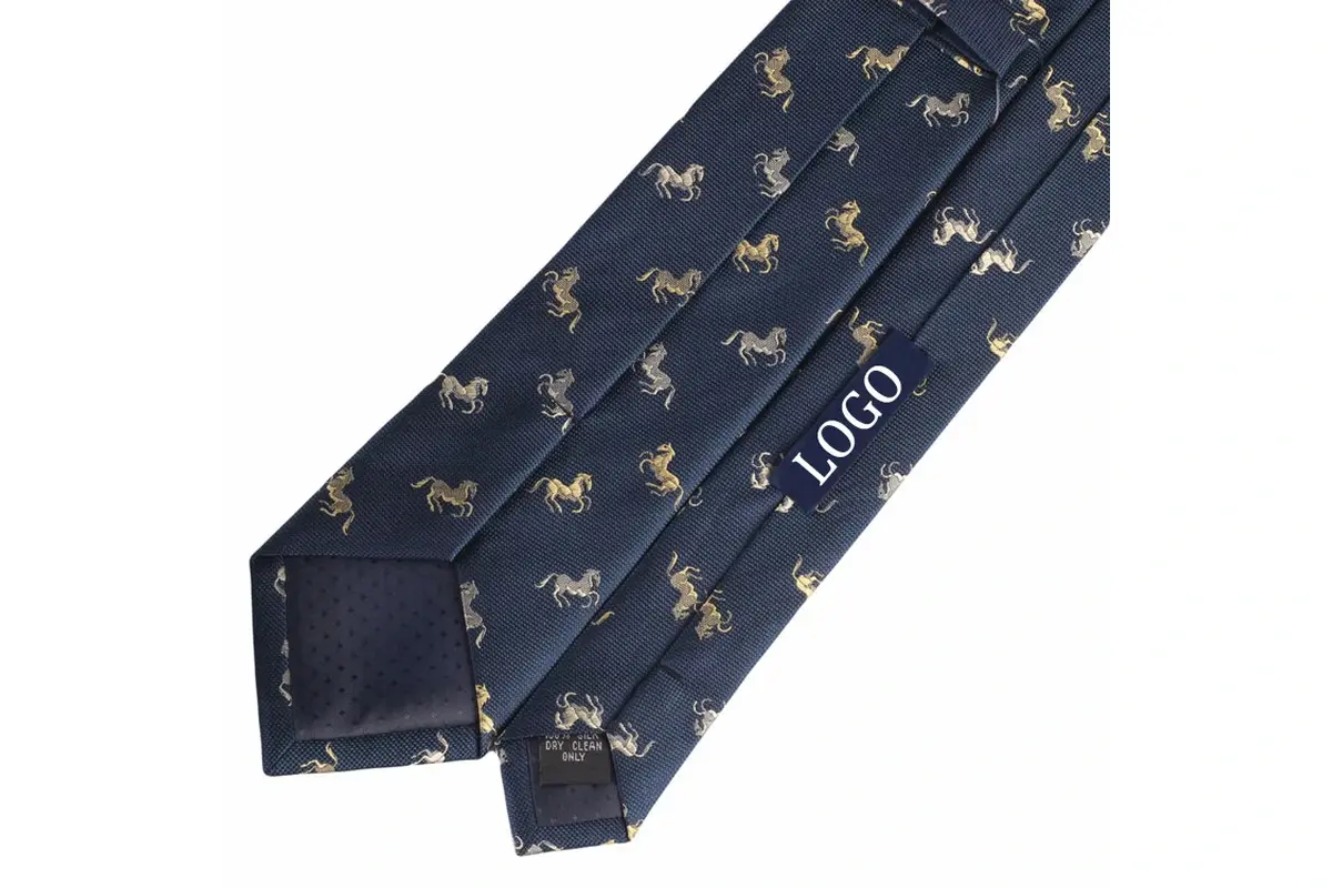 Navy patterned tie reverse with a sample label, center seam and dark tipping.