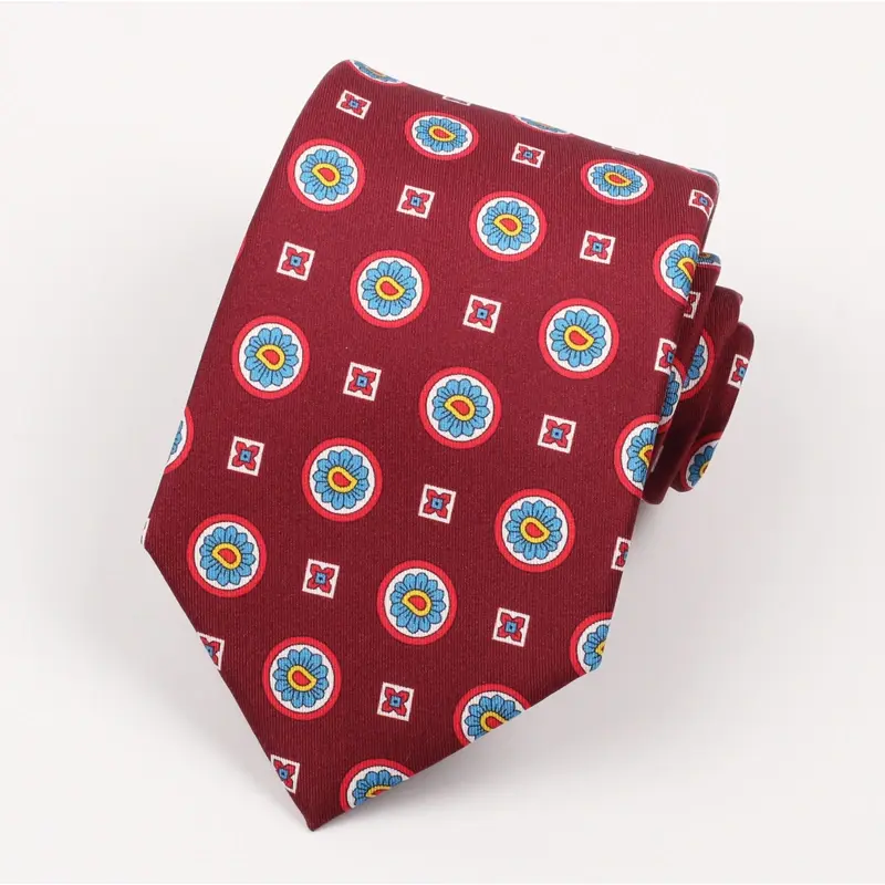 Red tie with repeated multicolor circular marks and small pale square motifs.