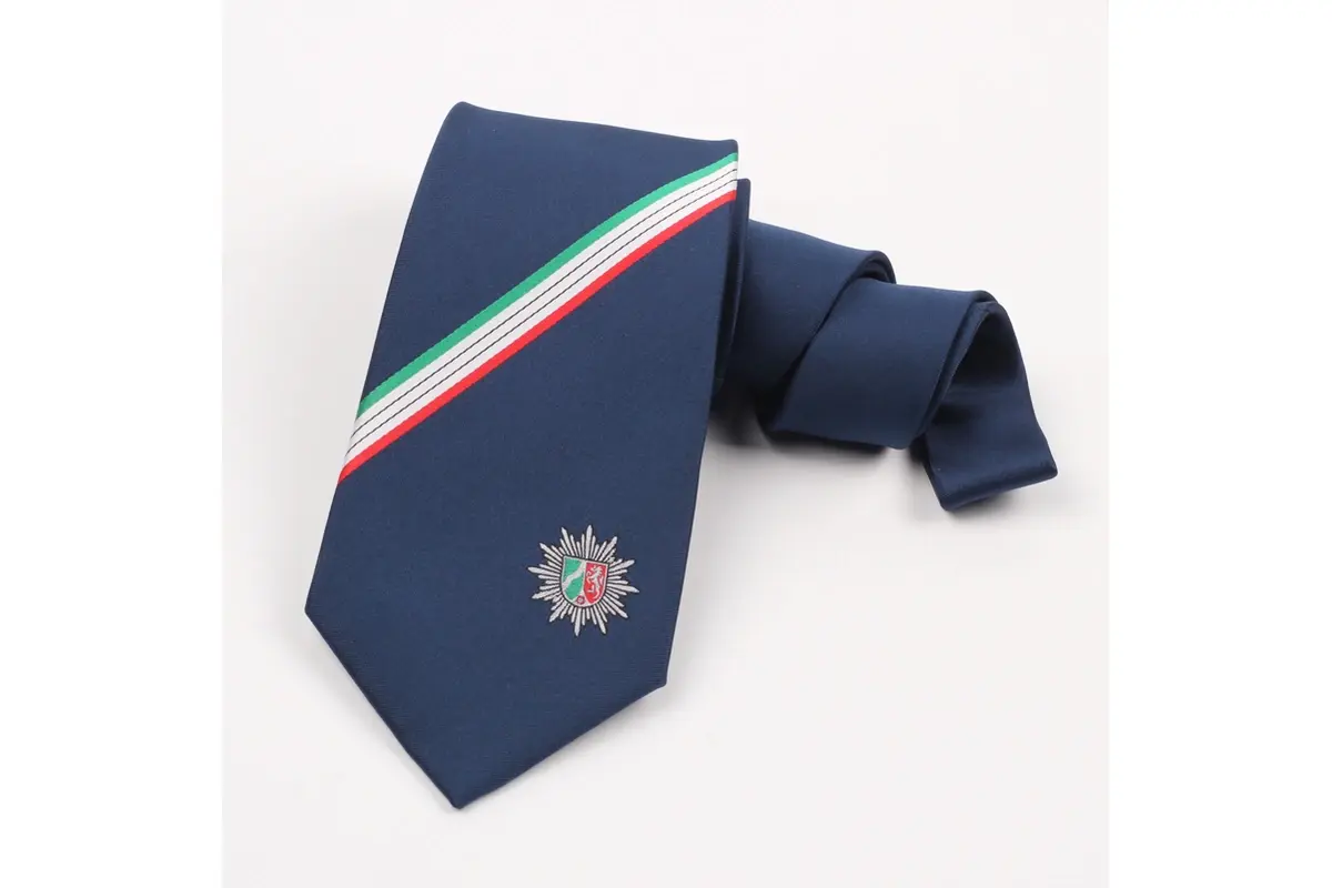 Navy tie with a multicolor crest below a green, white and red stripe.