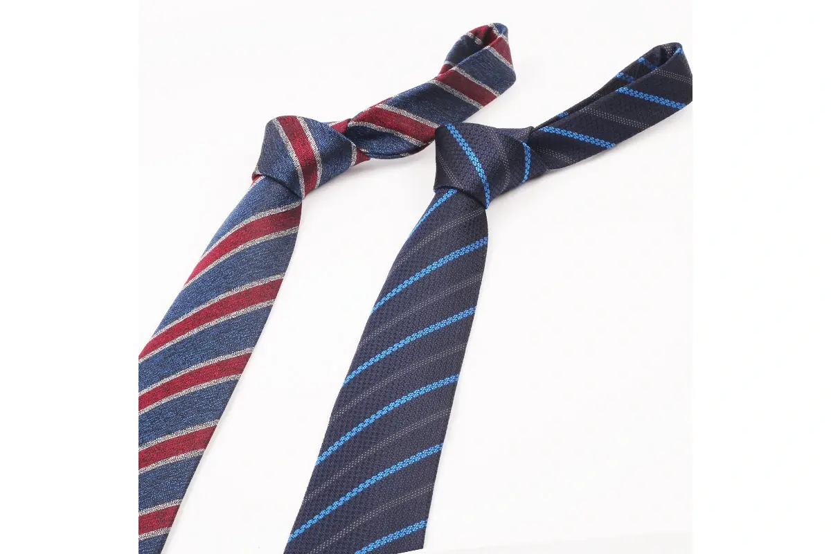 Two full knotted ties showing red and blue diagonal stripes on dark backgrounds.