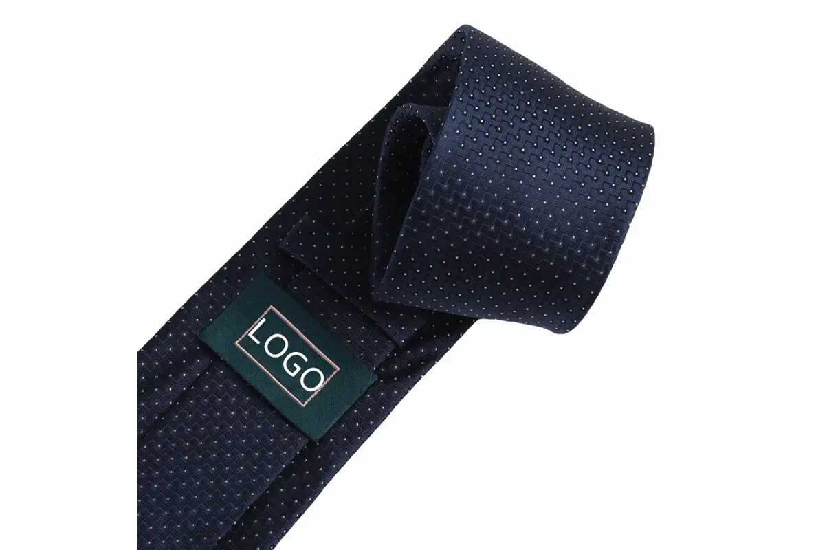Navy textured tie reverse with green sample logo label, folded edges and keeper.
