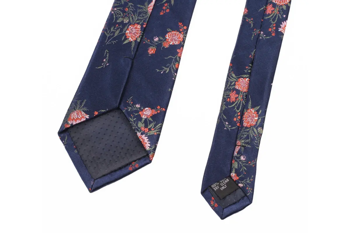 Navy floral tie reverse with pattern placement, center seam and dark tipping.