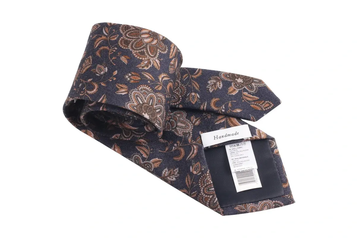 Patterned tie with a Handmade label and barcode tag visible on the reverse.