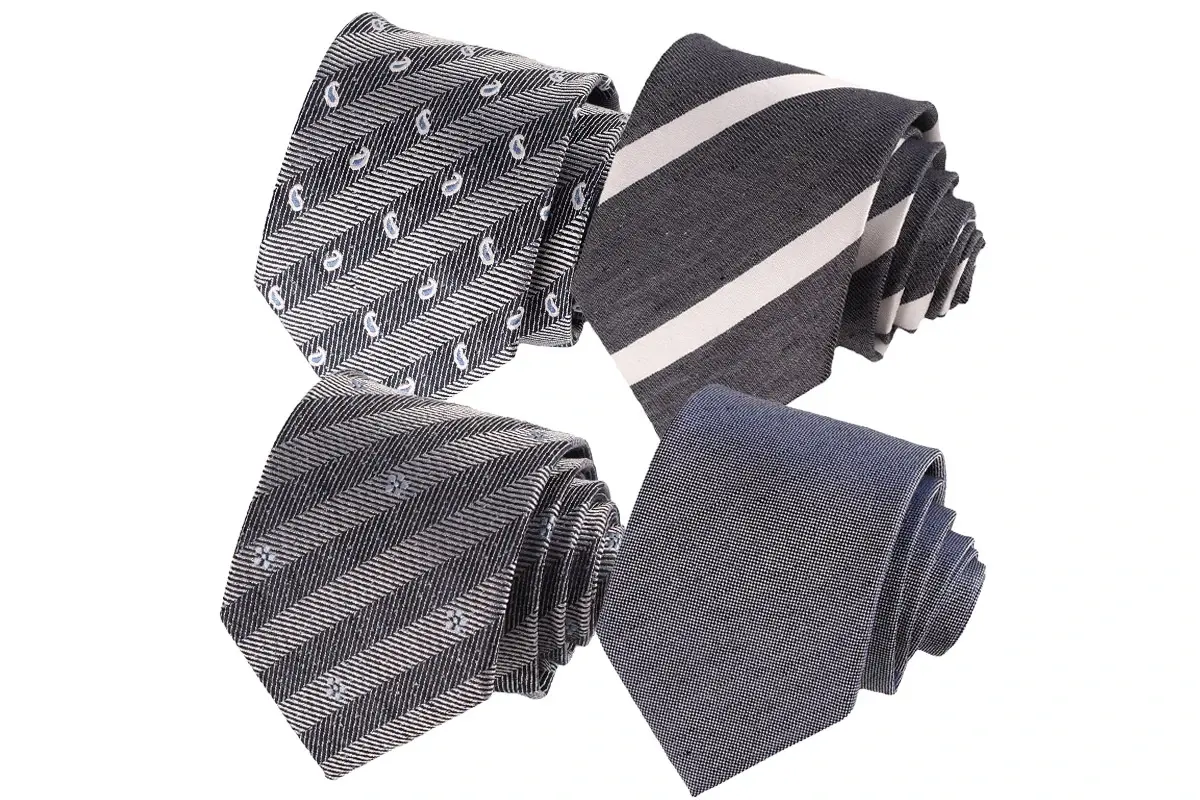 Four ties in gray and muted blue with plain, striped and small paisley patterns.
