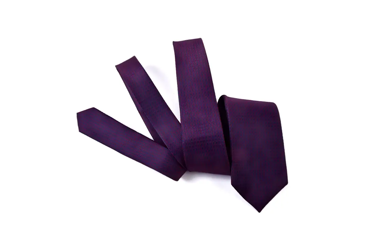 Purple tie arranged to show the wide blade and narrow tail.