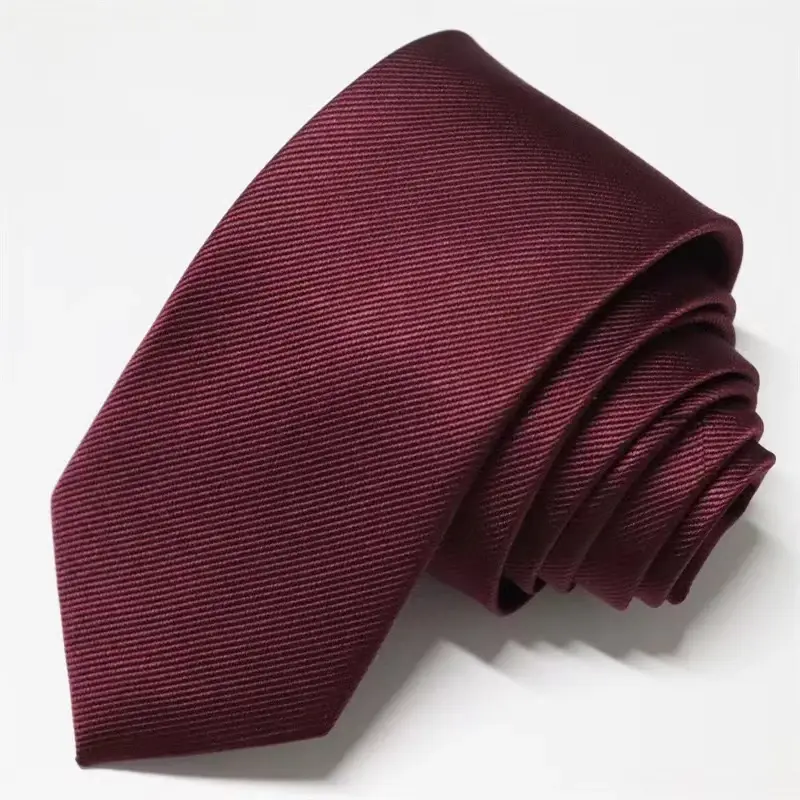 Rolled burgundy necktie on white background