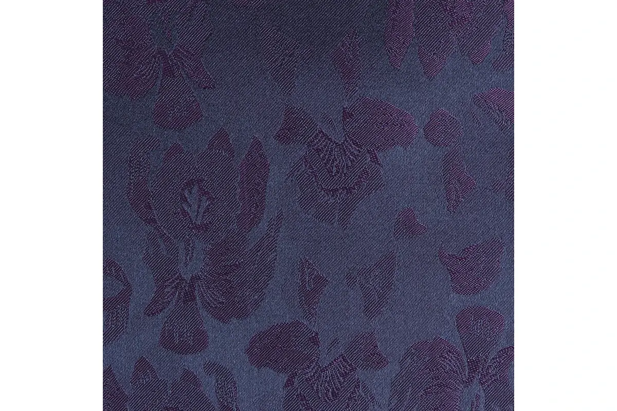 Close-up of dark floral motifs formed in a blue and purple fabric weave.