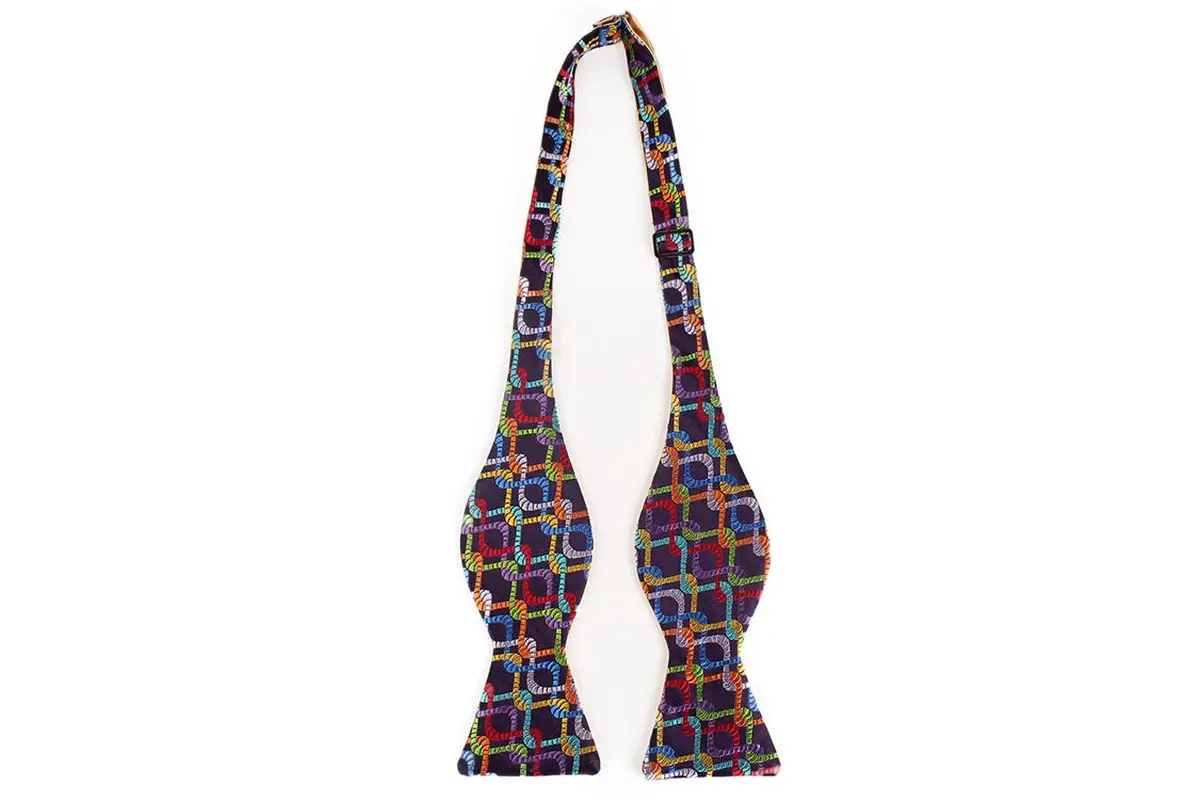 Multicolor patterned self-tie bow tie laid flat to show both wings and neck.