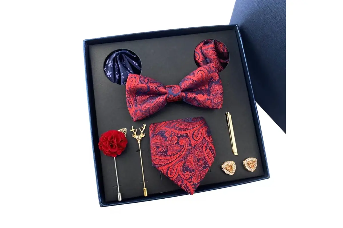 Open black gift box with red and navy bow ties.