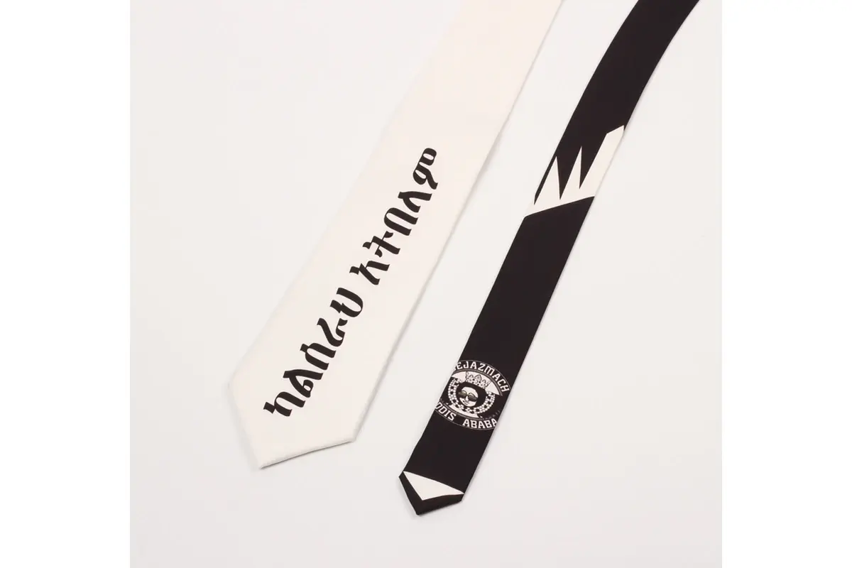 Two light and dark ties with large lettering and placed circular mark on blade.
