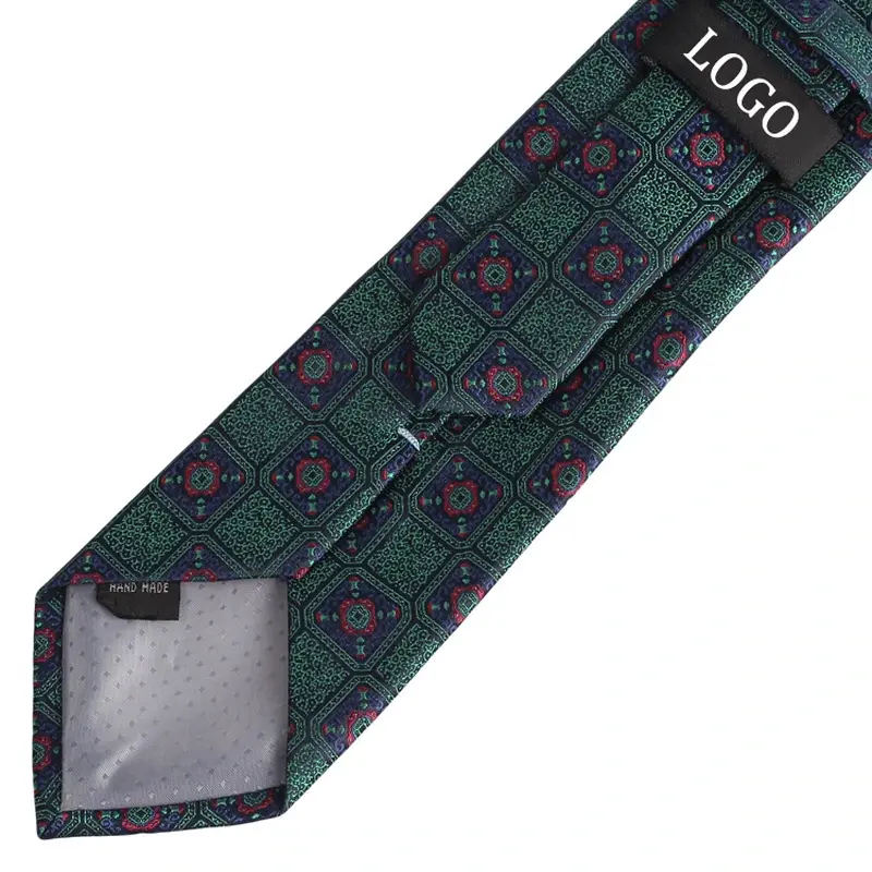 Green patterned tie reverse with a black sample logo label and pale tipping.