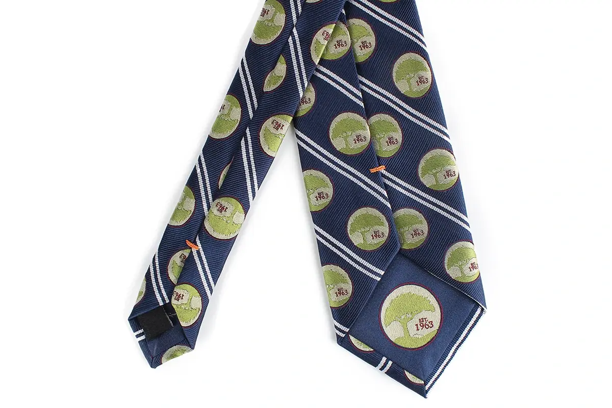 Navy tie with repeated green circular emblems placed between diagonal stripes.