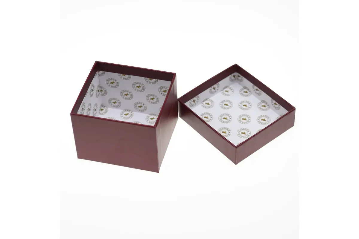 Open burgundy presentation box and separate lid with patterned interior lining.