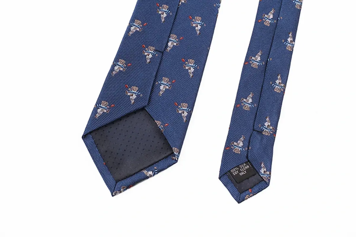 Blue patterned tie reverse with motif placement, folded blade edges, seam.