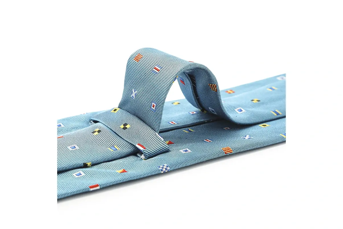 Light blue tie with small multicolor flag motifs visible across raised fold.
