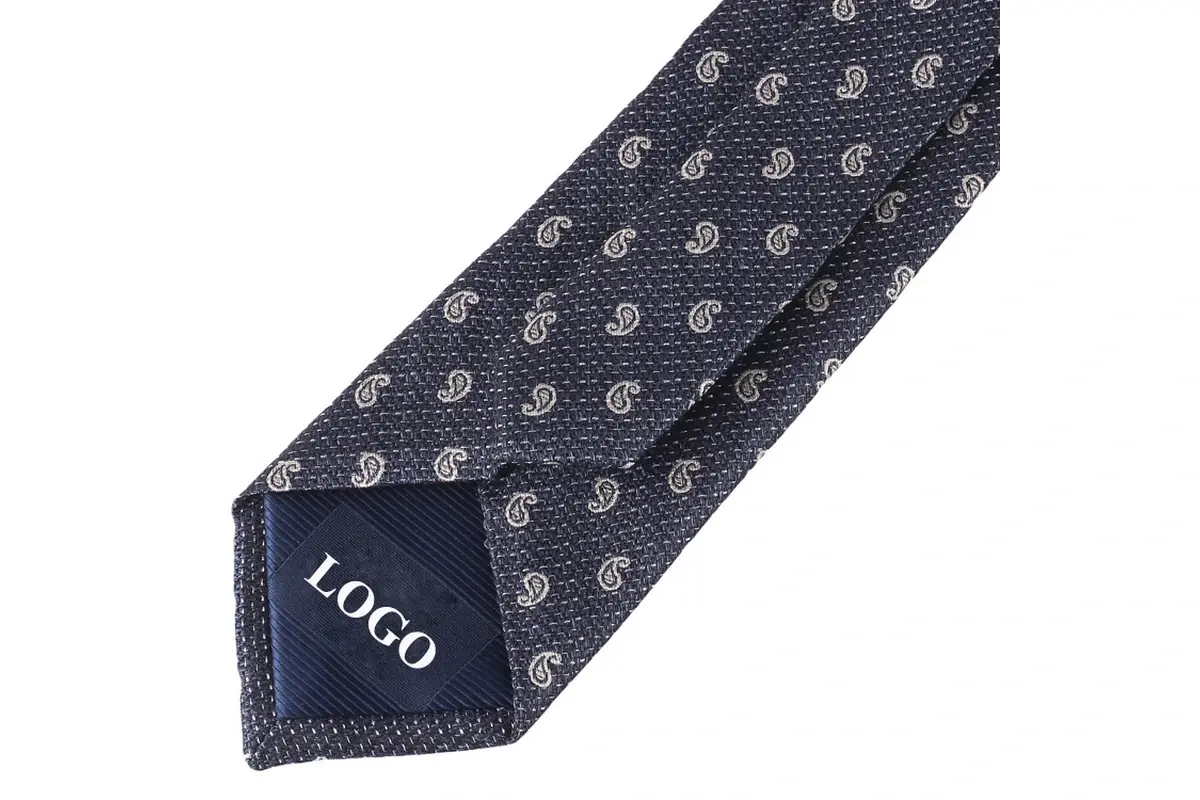 Navy paisley tie reverse with a sample LOGO mark on the dark tipping.