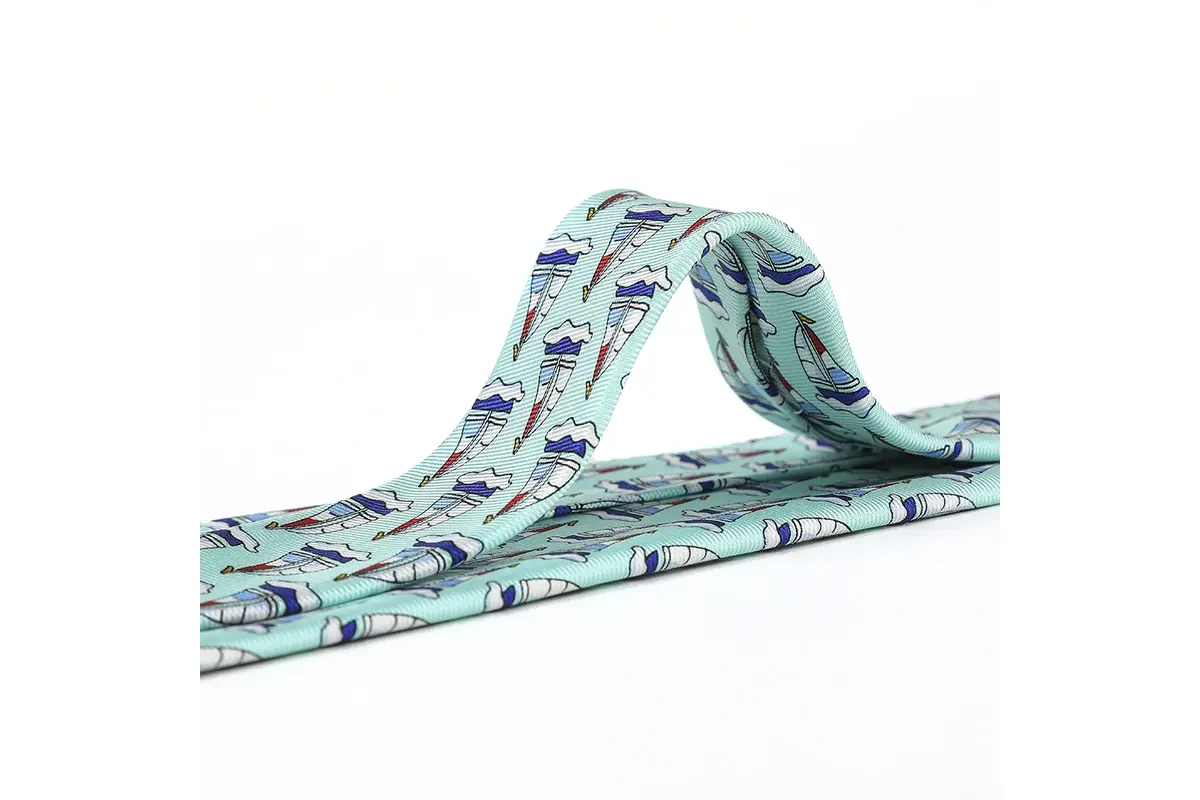 Mint tie with repeated sailboat motifs visible across the blade and raised fold.