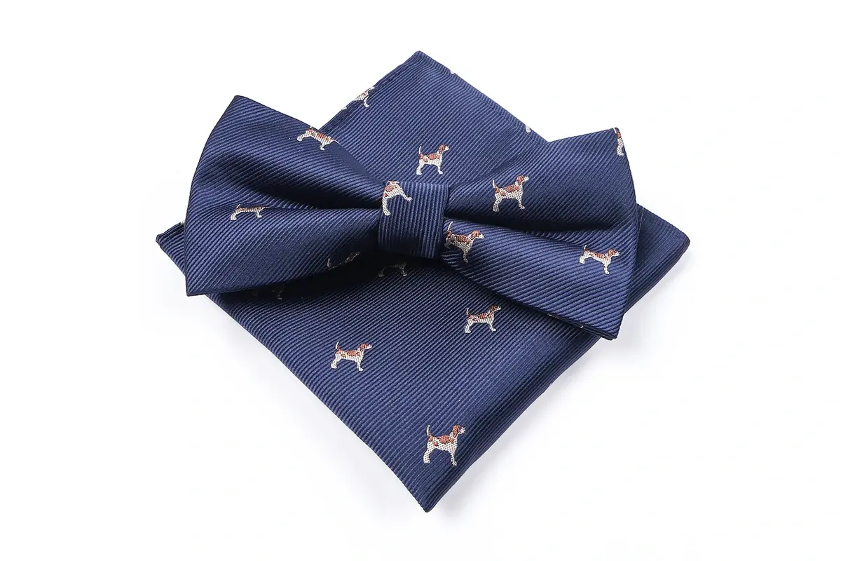 Navy bow tie and matching pocket square with small repeated dog motifs.