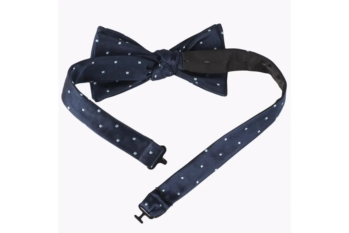 Navy pre-tied bow tie with pale dots, adjustable neck strap and hook.
