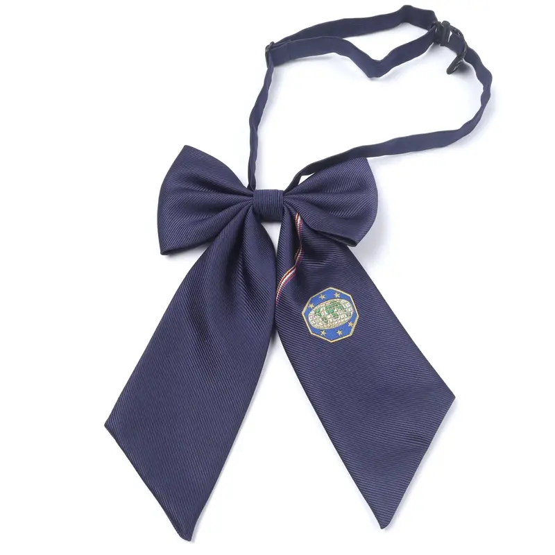Navy neck bow with long tails and a circular sample emblem tag.