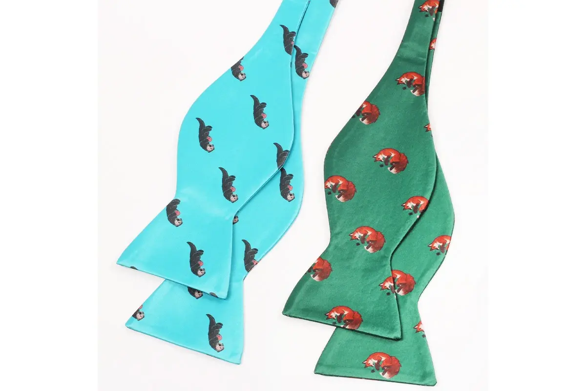 Turquoise and green self-tie bow ties with repeated animal motifs.