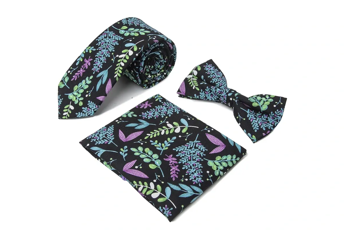 Black botanical tie with a matching bow tie and pocket square.