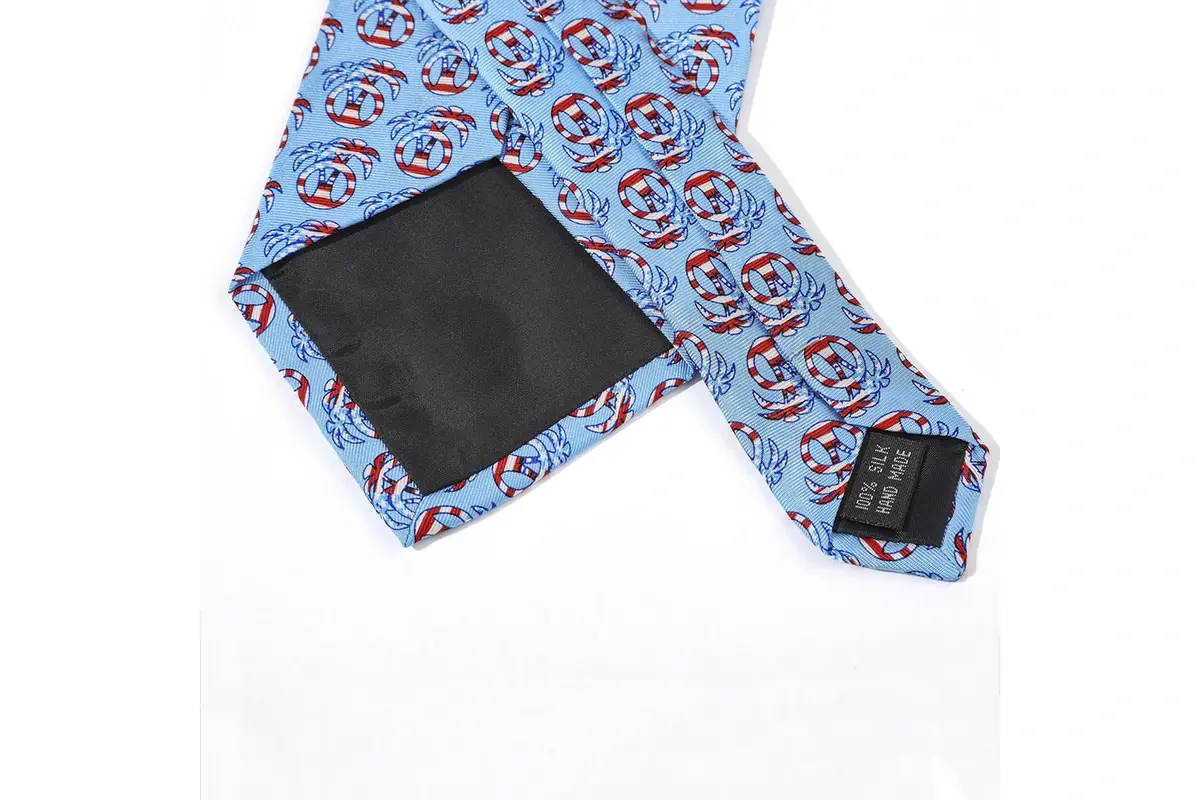 A light blue illustrated tie with the seam, dark tipping and label.