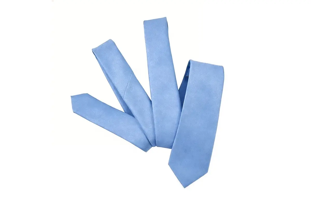 Light blue tie laid out to show the wide front blade and narrow tail.