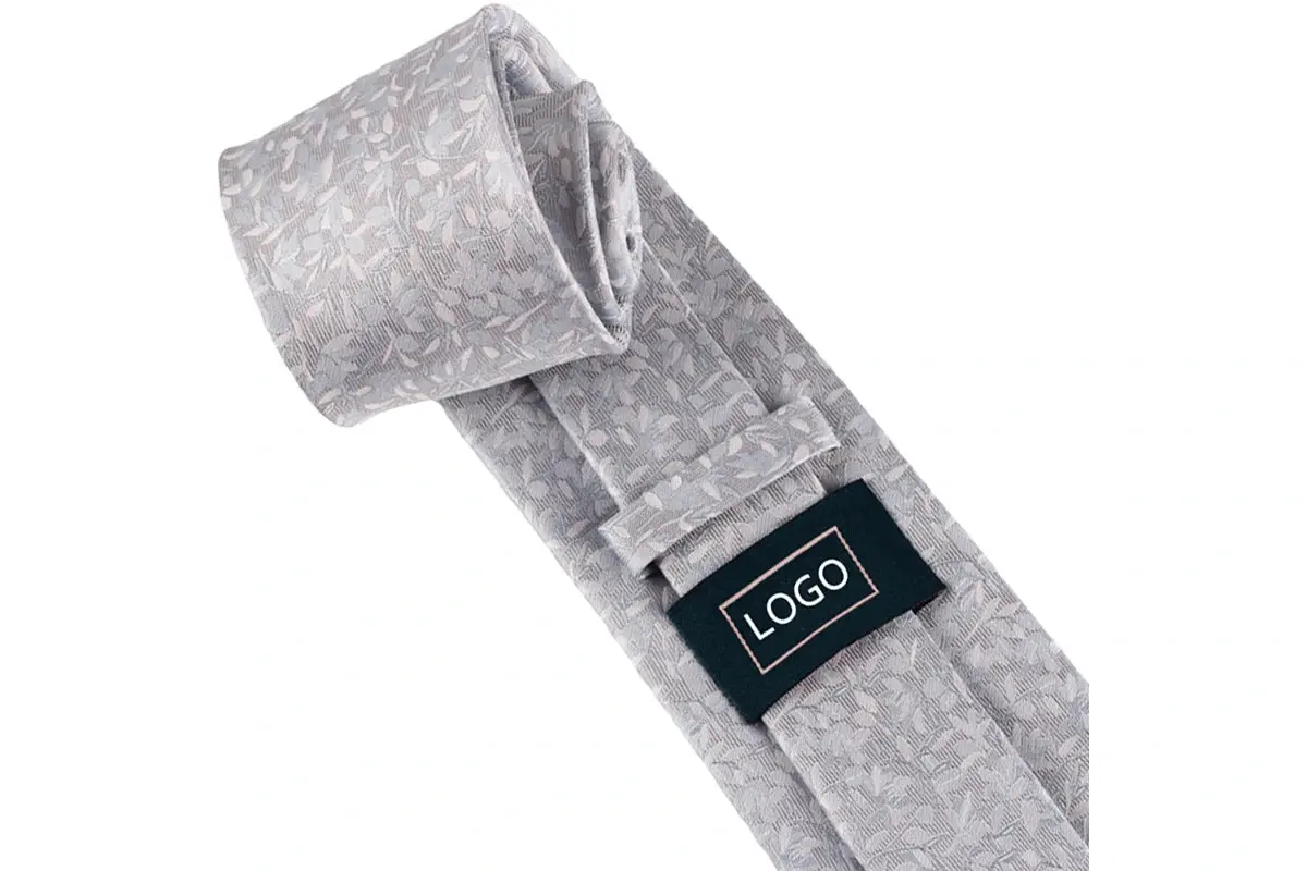 Silver floral tie reverse with a rectangular sample LOGO label and keeper.