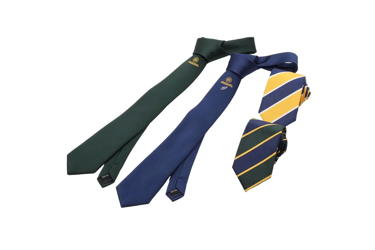 Green and navy knotted ties alongside two rolled yellow-striped ties.