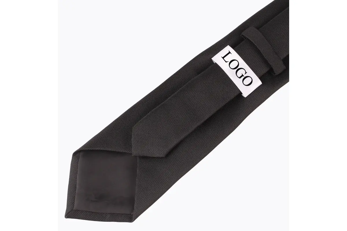 Black tie reverse with a white sample label, keeper loop and dark tipping.