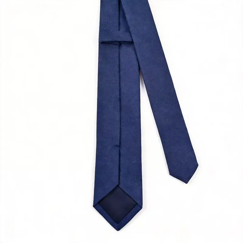 Plain navy tie showing the reverse seam, keeper loop and matching tipping.